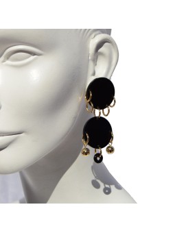 Pendientes ligeros hechos en plexiglass negro, latón bañado en oro y cristal. Cierre de clip.