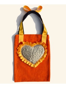 Bolso tote con corazón dorado sobre terciopelo vintage naranja